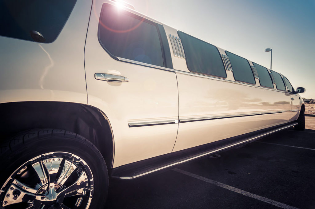 A white limo is parked in the parking lot.