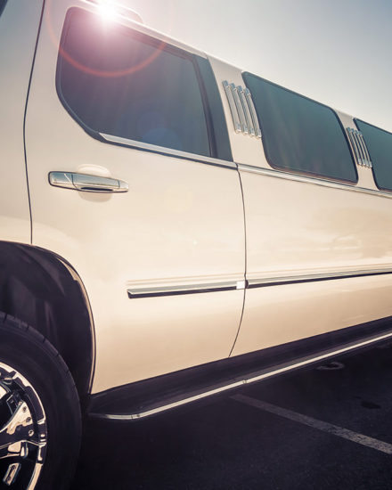A white limo is parked in the parking lot.