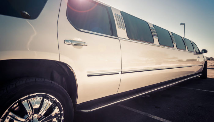 A white limo is parked in the parking lot.
