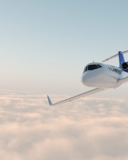 A plane flying through the air with clouds in background.
