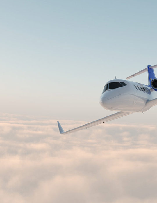 A plane flying through the air with clouds in background.