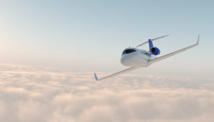 A plane flying through the air with clouds in background.
