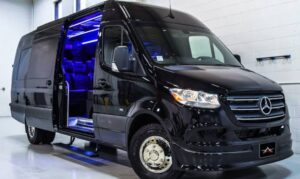 Black luxury van with open sliding door and blue interior lighting.
